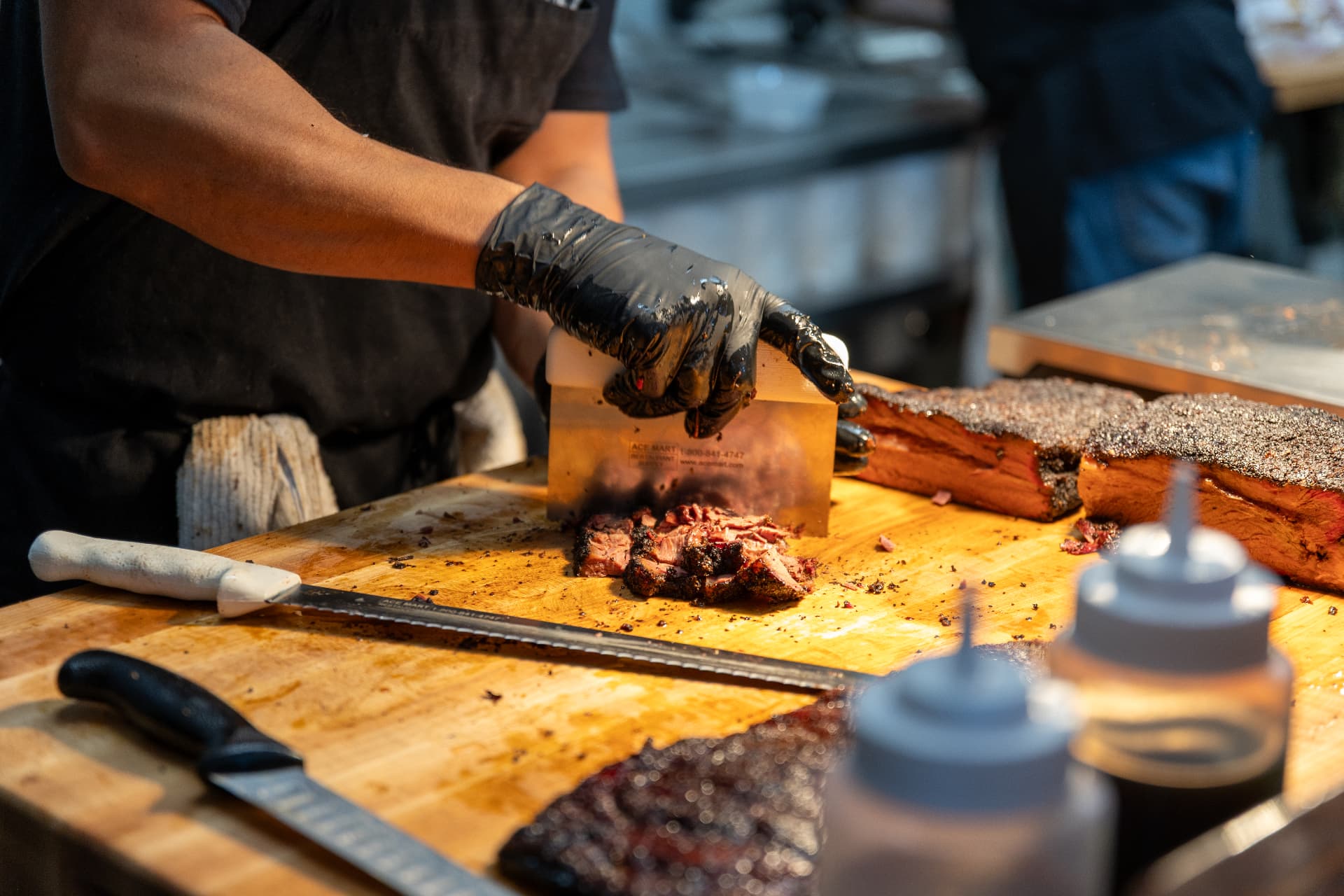Pitmaster chopping smoked brisket on a butcher block